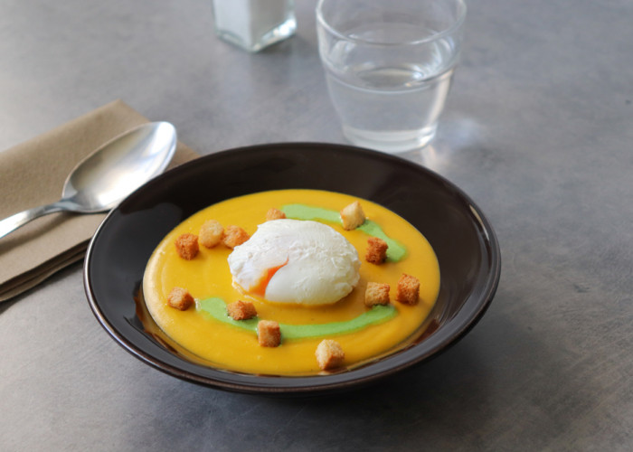 Velouté de carottes et pois cassés, oeuf poché et coulis d’herbes